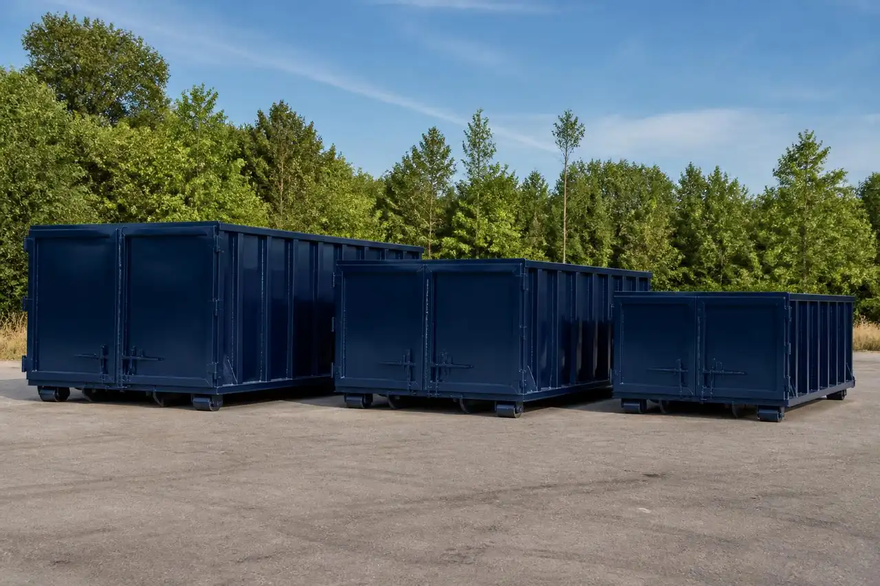 Roll-off dumpster positioned beside a garage with the door open for loading