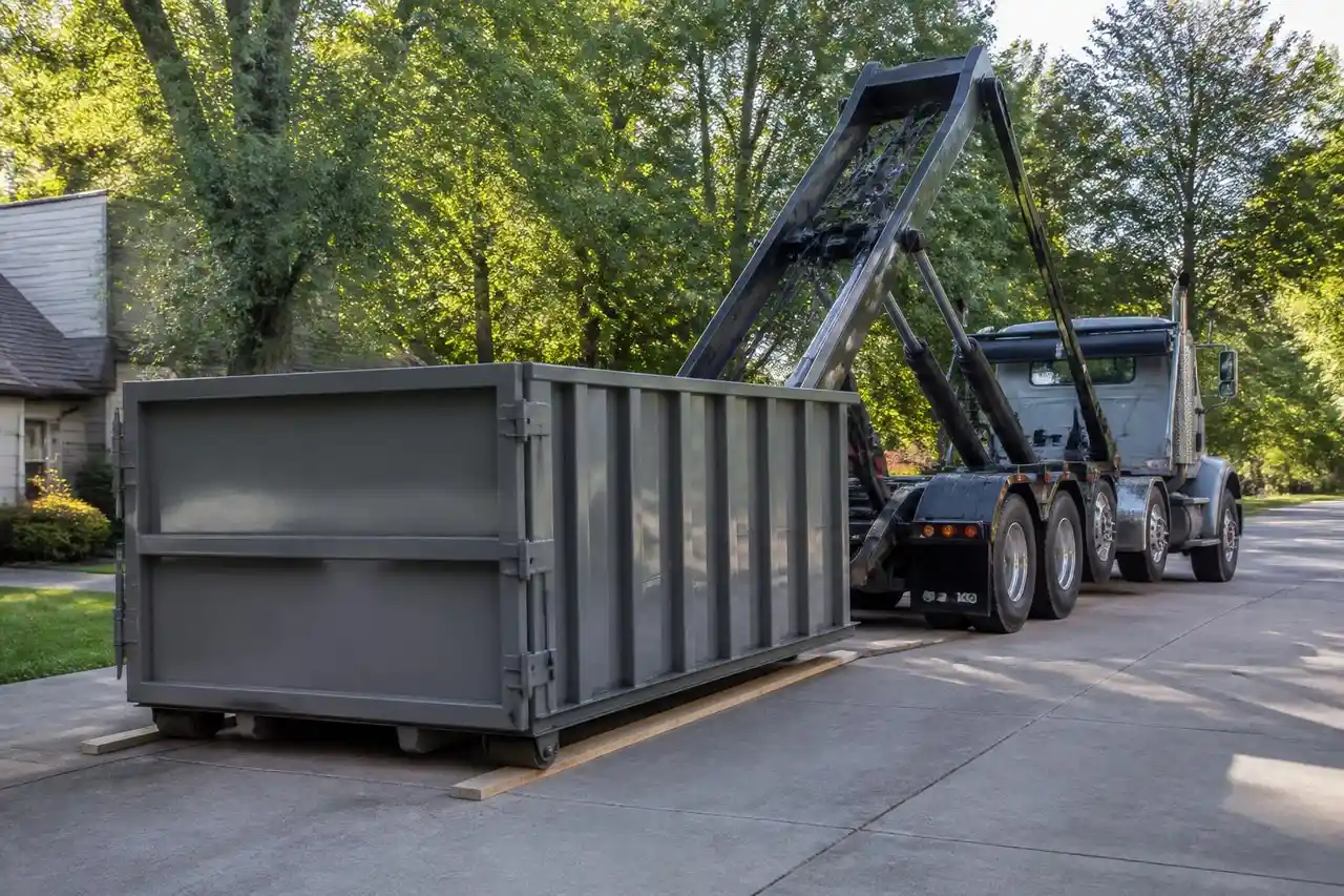 Roll-off truck lowering an empty container into place on a residential street